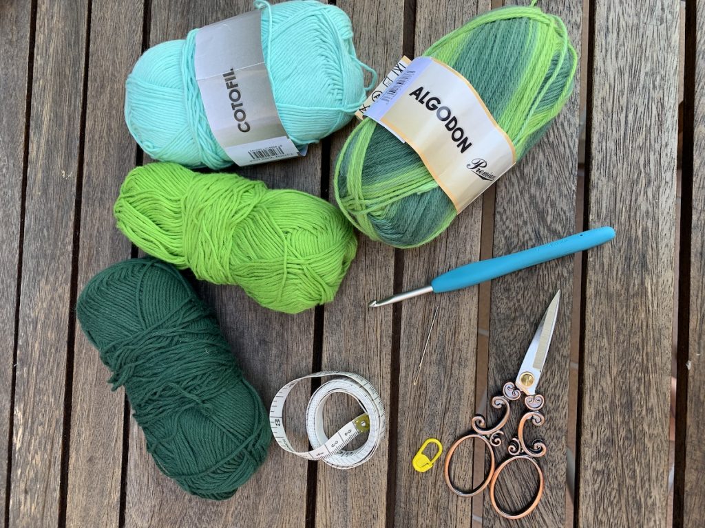 Material: 3 ovillos verdes de diferentes tonos y 1 ovillo verde matizado, tijeras, aguja lanera, crochet 4,5mm, metro y marcador de puntos.